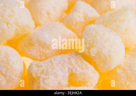 Bastoncini di mais giallo dolce con fondo di zucchero a velo, primo piano. Foto Stock