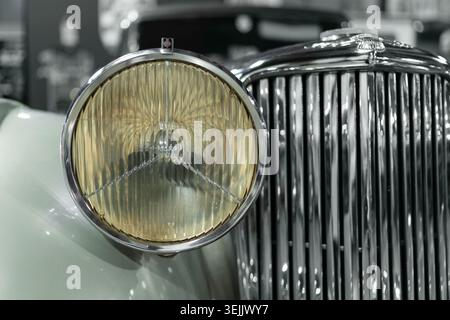 Milano, Italia - 12.11.2022: Primo piano del faro e della griglia Jaguar Mark IV vintage con elementi di design classici. Milano Autoclassica Foto Stock