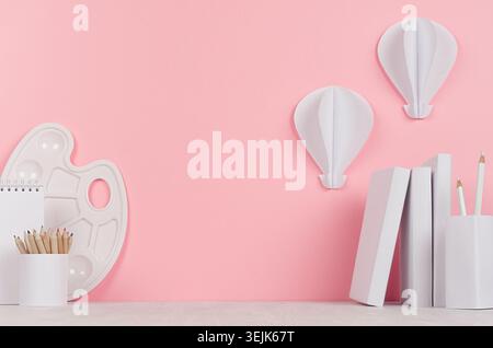 Luogo di lavoro creativo per disegnare: Accessori per la pittura, articoli di cancelleria e balloni ad aria calda origami su tavolo e sfondo rosa. Indietro Foto Stock