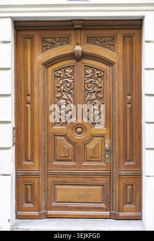 La porta d'ingresso ad un edificio residenziale, realizzato in legno e decorato con intagli Foto Stock