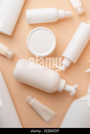 Gruppo di provette e contenitori bianchi per l'imballaggio per cosmetici su sfondo beige di colore naturale, design mockup, eco-compatibile Foto Stock