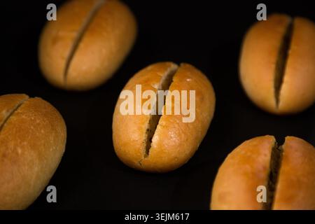 Golden Dinner Rolls appena sfornati su sfondo nero Foto Stock