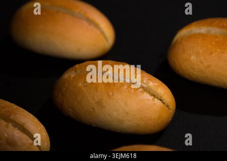 Golden Dinner Rolls appena sfornati su sfondo nero Foto Stock