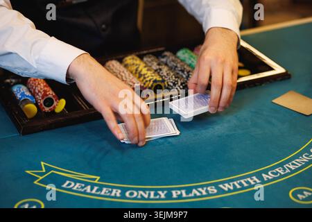 Carte di gioco del dealer Casino sul tavolo da poker blu Foto Stock