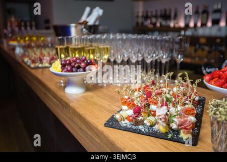 Tapas a bordo con pancetta, formaggio e pomodori ciliegini sul bancone del bar Foto Stock