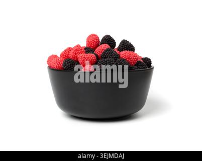 Bacche gommose in ciotola isolate, lamponi gommosi, more gelatine, caramelle di gelatina rossa e marmellata di frutta nera ricoperta di piccolo zucchero croccante Foto Stock