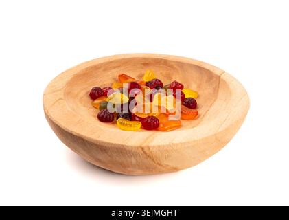 Pile di caramelle gommose di frutta in una ciotola di legno isolata, pillole vegane di marmellata da masticare, mucche di gelatina colorate su sfondo bianco Foto Stock