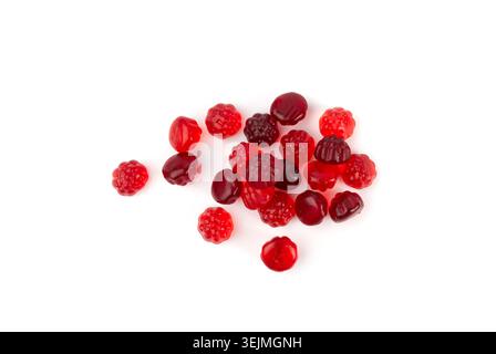 Mucchio di caramelle gommose di frutta isolato, pillole vegane di marmellata da masticare, mucchi di gelatina rossa di lampone, caramelle colorate di gelatina su sfondo bianco Foto Stock