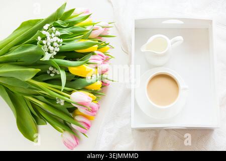 Colazione primaverile, caffè, caraffa del latte e torta con decorazioni di Giacinto rosa. Foto Stock