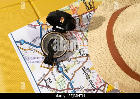 Accessori da viaggio su borsa gialla, mappa, cappello, bussola Foto Stock