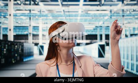 Indossare occhiali di protezione per la realtà virtuale, hardware e tecnico donna nella sala server per migliorare l'efficacia operativa. Monitoraggio di mainframe, tecnologia di realtà virtuale ed esperto IT in data center, telecamera A Foto Stock