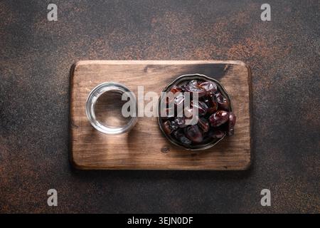 Ramadan. Datteri nella ciotola e acqua su marrone. EID Mubarak. Tradizione religiosa. Foto Stock