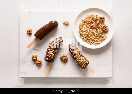 Banane surgelate e lolly al cioccolato. Dolci vegani fatti in casa. Foto Stock