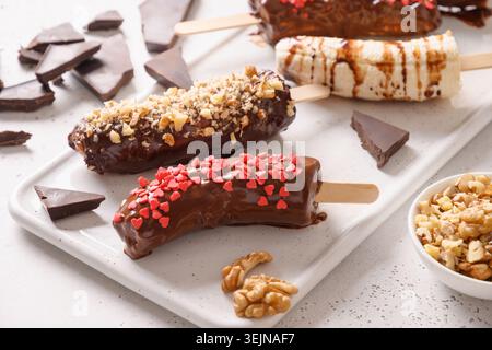 Banane surgelate e lolly al cioccolato. Dolci vegani fatti in casa. Foto Stock