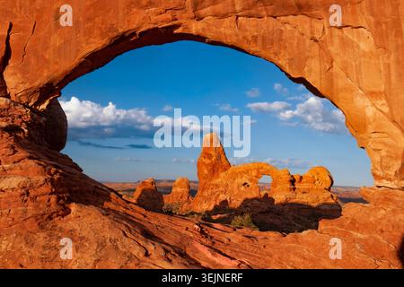 Una vista attraverso l'arco di roccia di North Window al mattino verso la formazione rocciosa di Turret Arch, Arches National Park, Utah, Stati Uniti Foto Stock