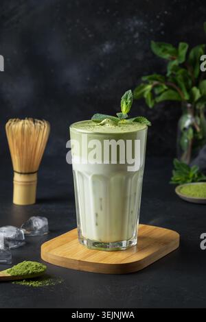 Bicchiere di tè Dalgona Iced Matcha sul nero. Foto Stock