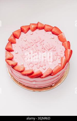 Torta rosa fatta in casa con un messaggio di iscrizione per il compleanno su sfondo bianco Foto Stock