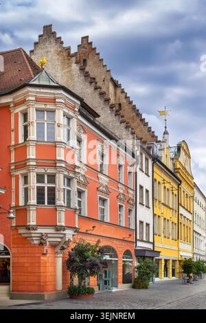 Edificio storico rosso con finestra ad angolo a Straubing, Germania. Case della città vecchia in una strada pedonale sotto il cielo nuvoloso Foto Stock