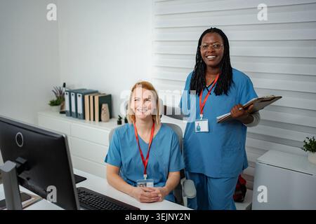 Diversi colleghi medici sorridono in un ufficio Foto Stock