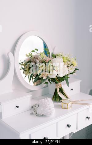 Ambiente tranquillo e sofisticato per la preparazione del matrimonio con bouquet floreale e accessori delicati Foto Stock