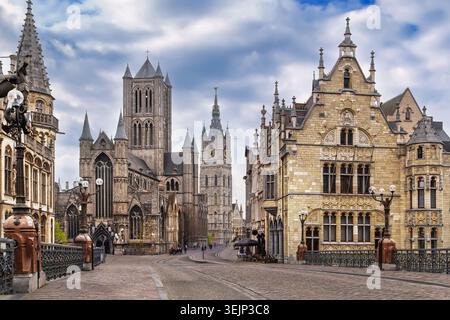Centro storico di Gand, Belgio, vista dal ponte. Panorama di torri medievali in pietra e chiese gotiche sotto il cielo nuvoloso Foto Stock
