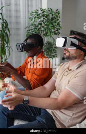 Le giovani coppie che indossano le cuffie per realtà virtuale stanno esplorando la metaversa Foto Stock