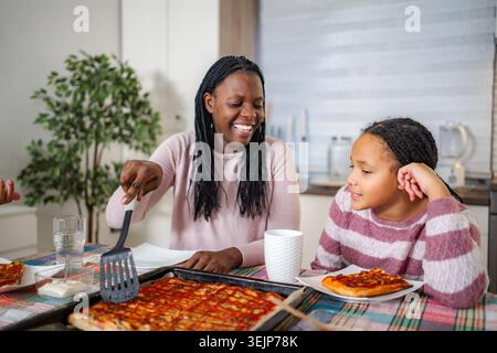 Mamma e figlia si gustano la pizza fatta in casa insieme Foto Stock