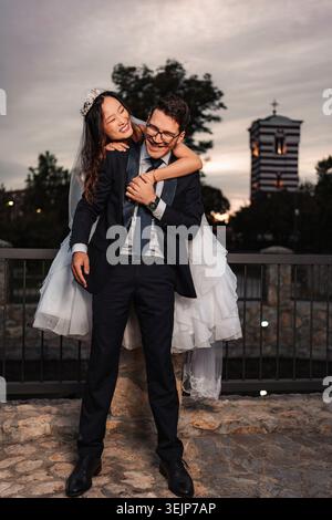 Felice matrimonio di coppia in gara mista all'aperto Foto Stock