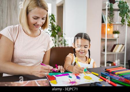 Madre e figlia si godono una sessione d'arte creativa a casa nel pomeriggio Foto Stock
