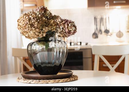 Interni accoglienti in autunno. Un bellissimo bouquet di ortensie secche in cucina. Foto Stock