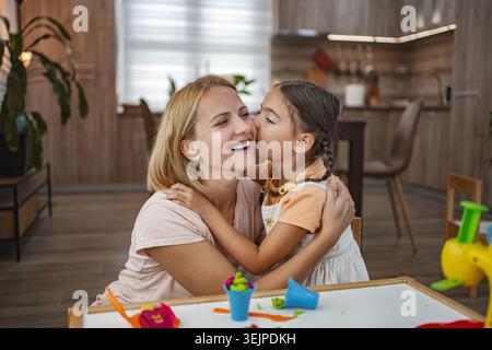 Madre e figlia condividono un momento di gioia a casa Foto Stock