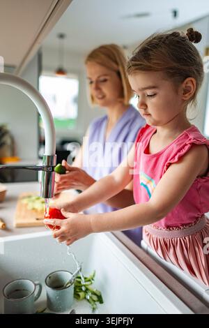 Mamma e figlia si divertono a cucinare insieme in cucina Foto Stock