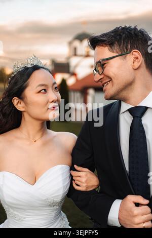 Coppia interrazziale che celebra il giorno del matrimonio guardarsi l'un l'altro Foto Stock