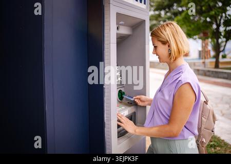 Goditi l'estate in Grecia utilizzando un bancomat Foto Stock