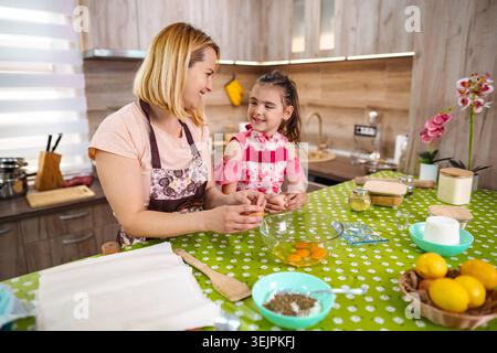 Divertimento pomeridiano di sole cucinando con mamma e figlia Foto Stock