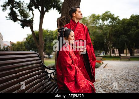 Coppia multiculturale che celebra il matrimonio in abiti tradizionali cinesi Foto Stock