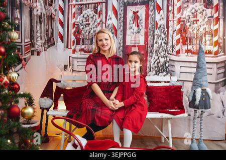 Madre e figlia che si tengono per mano per celebrare le vacanze di Natale Foto Stock
