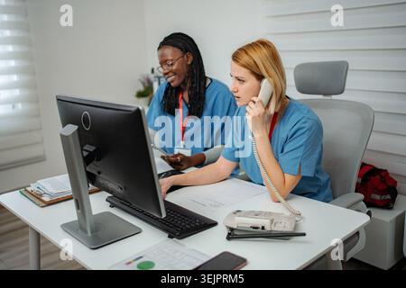 Diversi professionisti medici che forniscono supporto amministrativo in ufficio Foto Stock