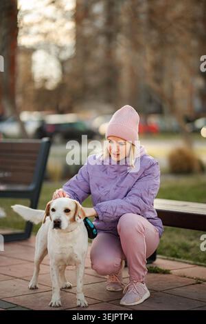 Donna che accarezza il cane labrador bianco all'aperto nel parco Foto Stock