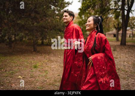 Coppia multiculturale che celebra il matrimonio in abiti tradizionali cinesi Foto Stock