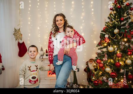Famiglia che festeggia il Natale con il bambino a casa Foto Stock