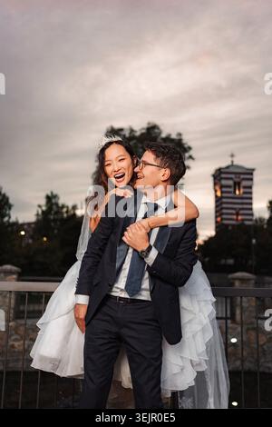 Felice coppia interrazziale che si gode il giorno del matrimonio all'aperto Foto Stock