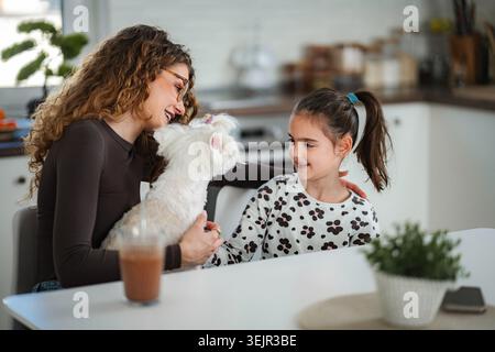 Madre e figlia felici si legano con il cane Foto Stock