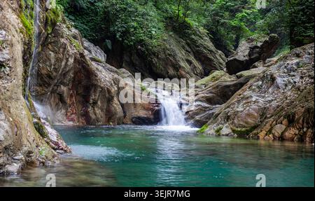 Fiume Sanzhanxi nel Parco Nazionale di Taroko. Una piccola cascata panoramica scorre in una piscina blu chiaro. Foto Stock