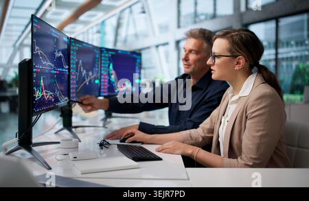 Focus Trader esamina più schermate che analizzano con sicurezza le tendenze del mercato azionario. Foto Stock