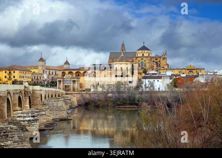 Vista della cattedrale della moschea dal ponte romano a Cordova, Spagna. Storico skyline della città sul fiume Guadalquivir, cielo nuvoloso Foto Stock