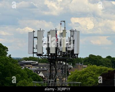 Cambridge, Regno Unito - 17 maggio 2026: Torre cellulare con antenne e bandiera Union Jack sopra gli alberi Foto Stock
