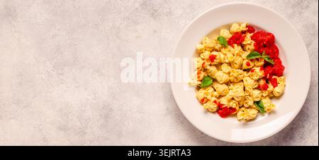 Pasta ripiena italiana. Sacсhettini pasta in un piatto con salsa di pomodoro. Foto Stock
