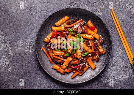 Tteokbokki, torta di riso fritta piccante con manzo e verdure. Foto Stock