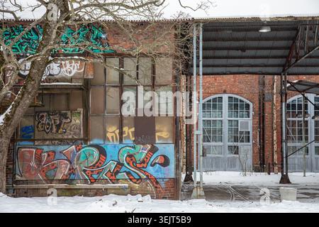 Vecchie sale industriali ricoperte di graffiti del quartiere Konepaja nel quartiere Vallila di Helsinki, Finlandia Foto Stock